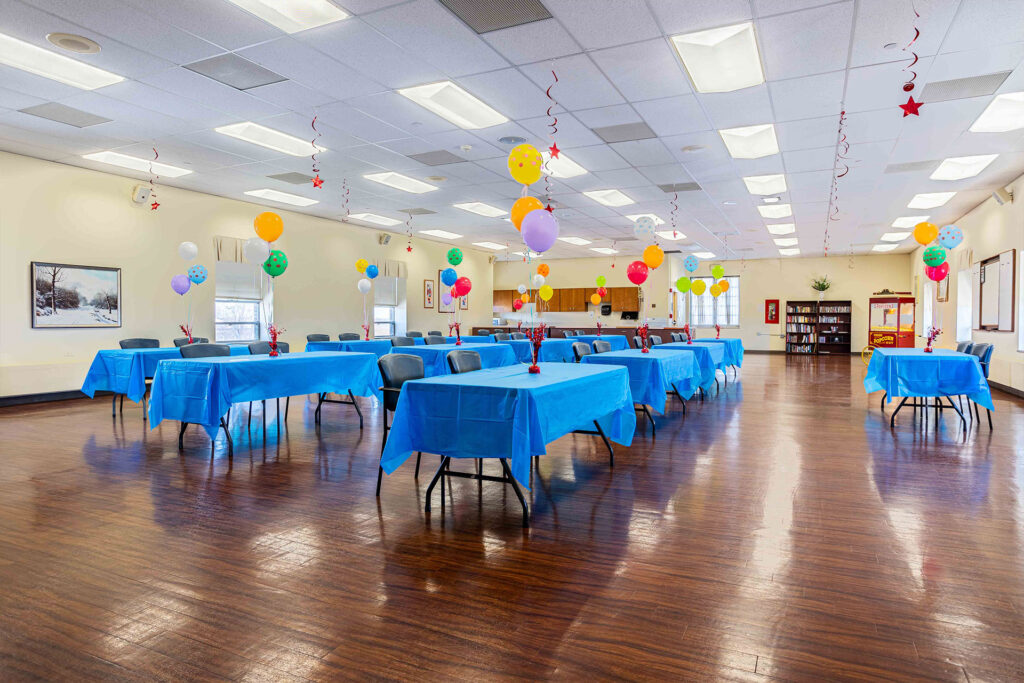 Celebrate Senior Living room with tables for a birthday celebration.